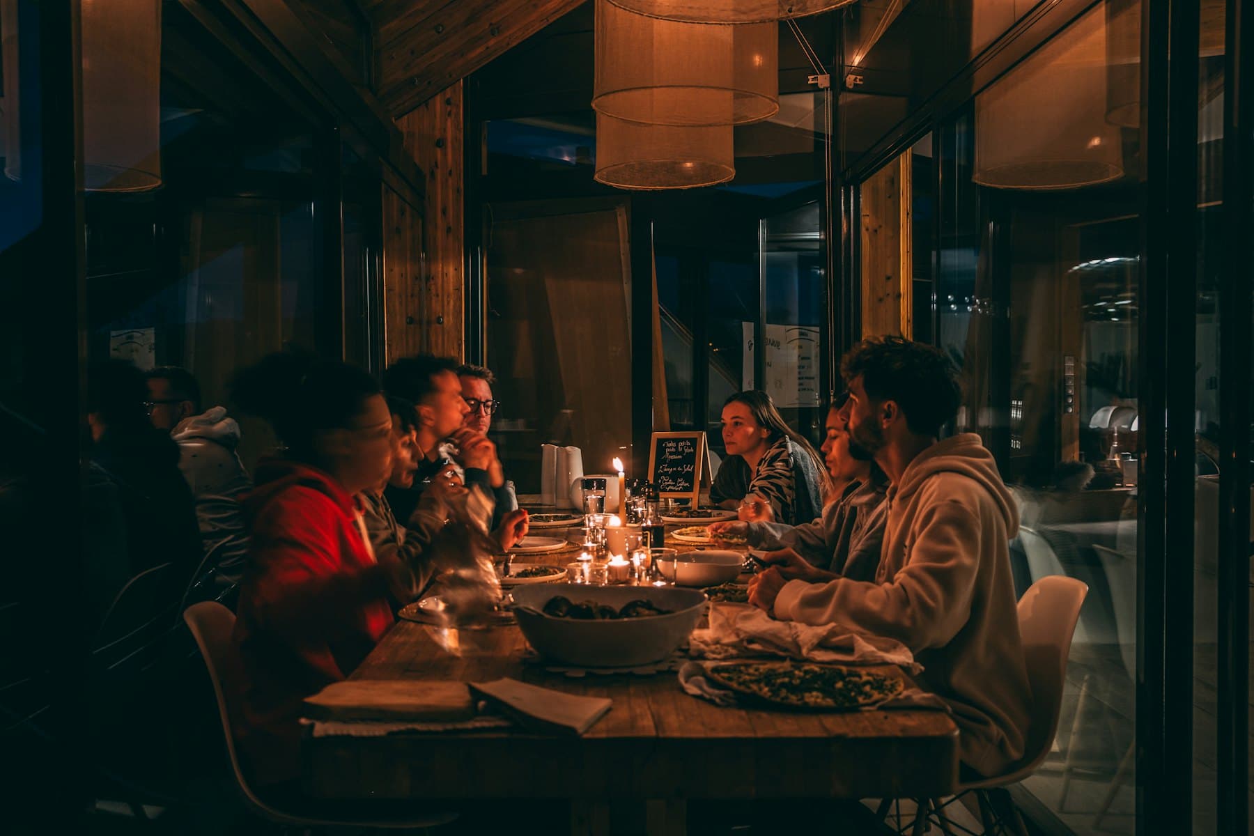 Mum ışığında akşam yemeği yiyen misafirlerle dolu bir restoran